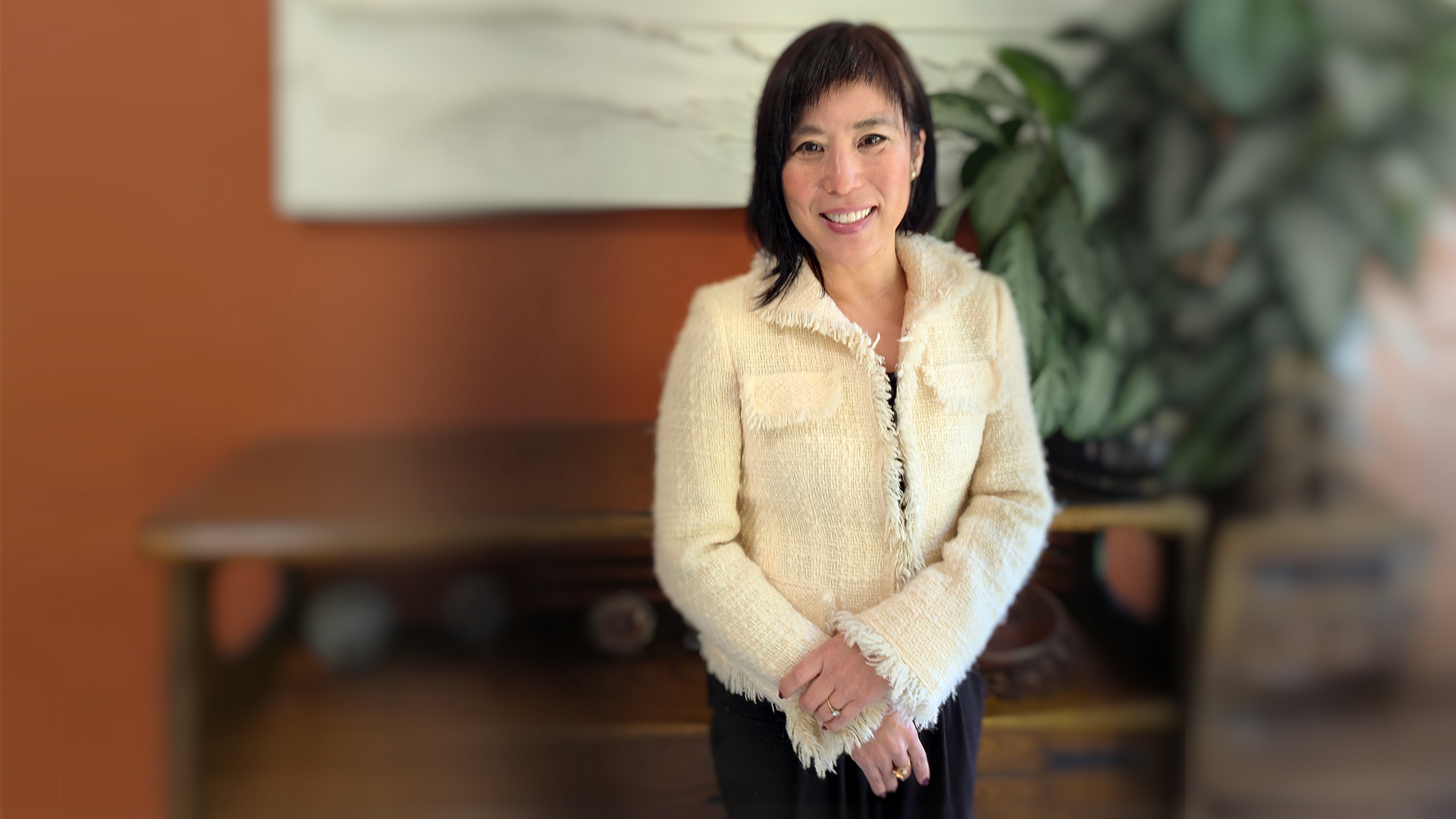 Dr. Mikiko Murakami smiling in her office, representing compassionate regenerative and pain medicine care in the Bay Area.